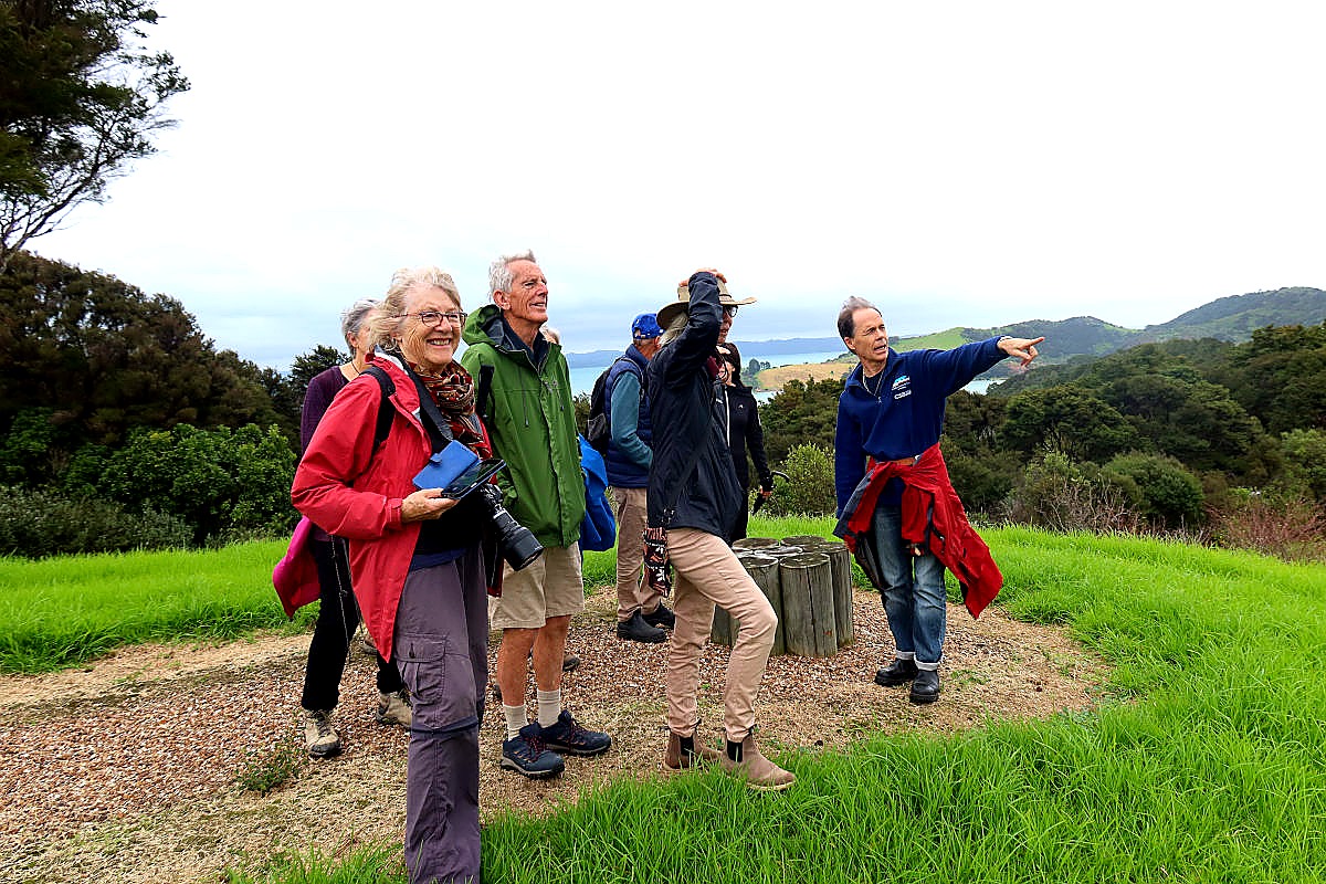 Guided walk group at a viewpoint overlooking Te Matuku Bay, Waiheke Island
